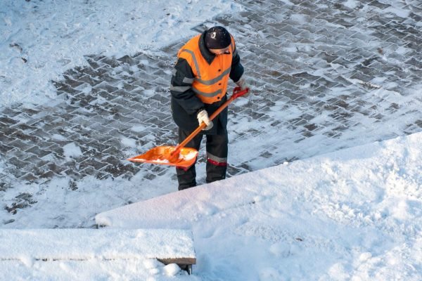 removing-snow-from-sidewalk-after-snowstorm-road-worker-with-shovel-his-hands-special-clothes-cleans-sidewalk-road-from-snow-snowstorm-hurricane-city (1)